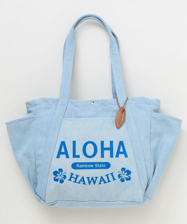 ALOHA HAWAII ロゴ入りデニムトートバッグを肩掛けしたコーディネート