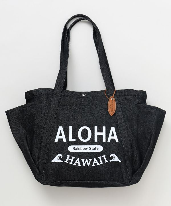 ALOHA HAWAII ロゴ入りブラックデニムトートバッグを肩掛けしたコーディネート
