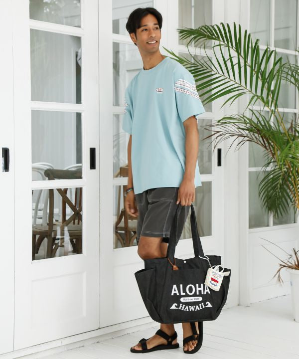 ALOHA HAWAII ロゴ入りブラックデニムトートバッグを肩掛けしたコーディネート