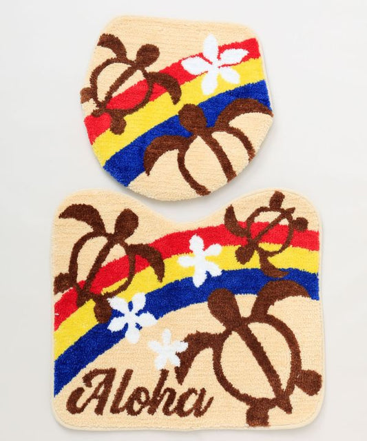 ホヌと虹が描かれたハワイアンデザインのトイレマットとフタカバーセット。立体的な刺しゅうが特徴の南国インテリア。